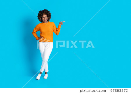 Full length of stylish black lady pointing at copy space Full length of stylish black lady pointing at copy space 97863372