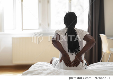 Black Man Suffering Lower Back Pain After Sleeping In Uncomfortable Bed 97863505
