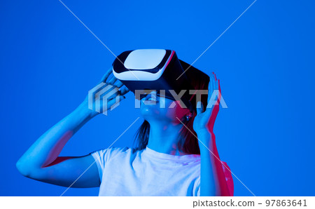 Impressed brunette woman using virtual reality headset, getting immersed experience, interacting with immersive digital world, testing VR technology for work. 97863641