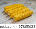 five yellow ears of corn lie on a light gray background 97865028
