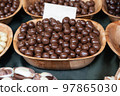 chocolate candies, nuts in chocolate glaze close-up in a plate 97865030