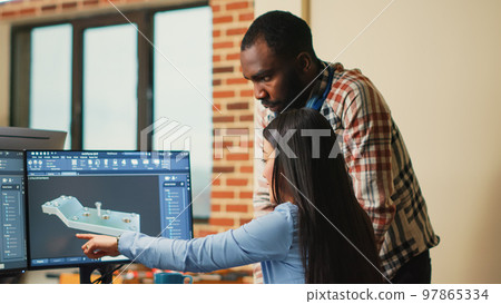 Creative 3D artists discussing about machinery development, working together on clamp prototype. Professional graphic engineers developing industrial engine product using specialized software. 97865334