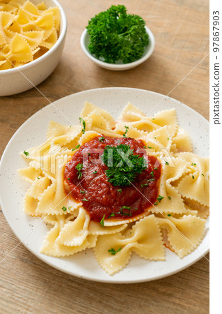 farfalle pasta in tomato sauce with parsley 97867903