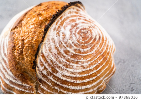 Freshly baked loaf of a wheat sourdough bread with marks from bread proofing basket. Freshly baked loaf of a wheat sourdough bread with marks from bread proofing basket. 97868016