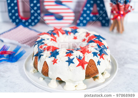 July 4th bundt cake covered with a vanilla glaze and decorated with chocolate stars on a white plate. 97868989