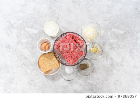 Flat lay. Measured ingredients in glass mixing bowls to make meatloaf. Flat lay. Measured ingredients in glass mixing bowls to make meatloaf. 97869057