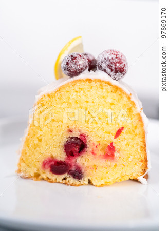 Slice the lemon cranberry bundt cake on a white plate. Slice the lemon cranberry bundt cake on a white plate. 97869170