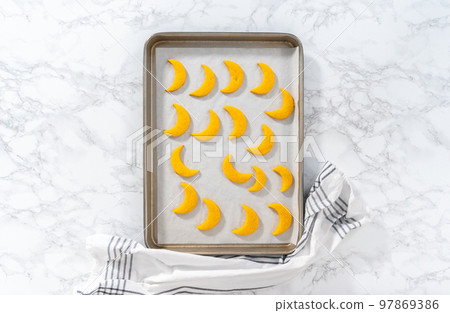 Flat lay. Lemon wedge cookies with lemon glaze. Cooling freshly baked lemon wedge cookies on a kitchen counter. Flat lay. Lemon wedge cookies with lemon glaze. Cooling freshly baked lemon wedge cookies on a kitchen counter. 97869386