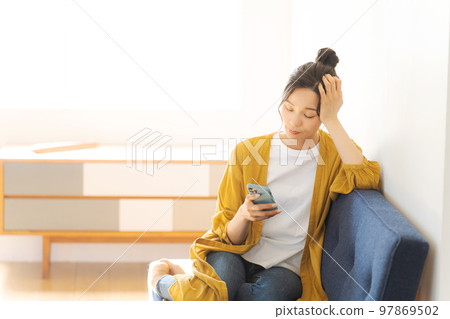 A woman watching a smartphone A woman watching a smartphone 97869502