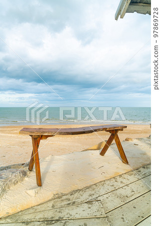 wood bench on beach with sea beach background 97869728