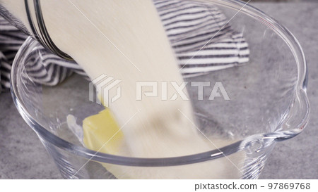Mixing ingredients into the batter for lemon pound cake. Mixing ingredients into the batter for lemon pound cake. 97869768