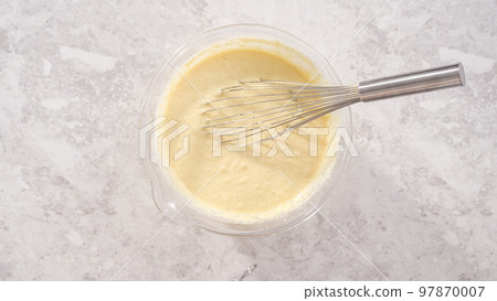 Flat lay. Step by step. Mixing ingredients in a glass mixing bowl to prepare coconut banana pancakes. 97870007