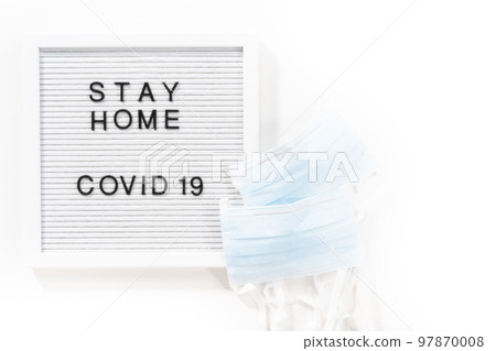 STAY HOME and COVID-19 sign on message board with a blue medical mask. 97870008