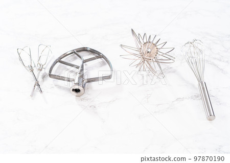 Close-up view. Variety of blending whisks on a marble countertop. 97870190