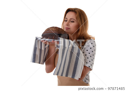 studio portrait of woman in apron smelling a sourdough homemade bread, isolated on white background studio portrait of woman in apron smelling a sourdough homemade bread, isolated on white background 97871485