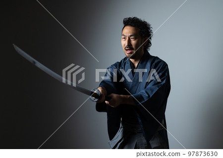 A man with a mustache playing with a Japanese sword (hakama version) A man with a mustache playing with a Japanese sword (hakama version) 97873630