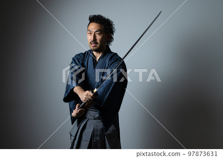 A man with a mustache playing with a Japanese sword (hakama version) A man with a mustache playing with a Japanese sword (hakama version) 97873631
