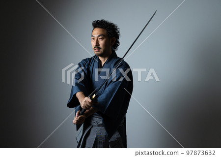 A man with a mustache playing with a Japanese sword (hakama version) A man with a mustache playing with a Japanese sword (hakama version) 97873632