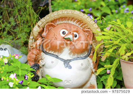 花園裡一個可愛的浣熊雕像 花園裡一個可愛的浣熊雕像 97875029