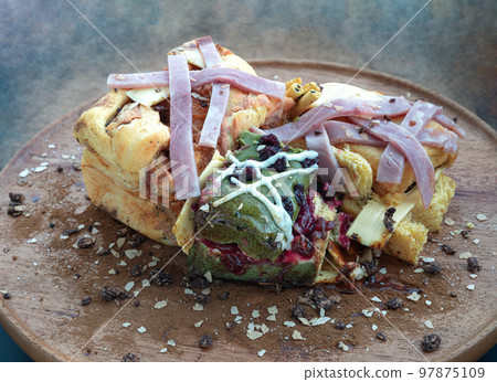 Brioche Truffle Ham Cheese Pumpkin Bread, mixed with Cheese Cake Christmas Protein Bar and mixed nuts sprinkle on the wooden tray. 97875109