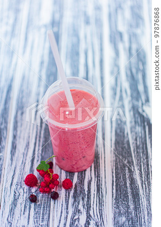 From above view of berries milkshake in plastic cup with ingredients on wood background. Vegan food 97876868