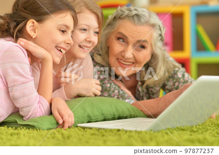 senior woman with granddaughters looking at laptop senior woman with granddaughters looking at laptop 97877237