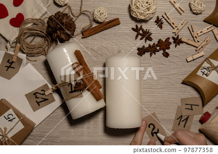 Unrecognizable young woman paint numbers on candles. Female making homemade advent calendar Made with your own hands step by step DIY crafts do it yourself. Preparation to christmas concept. Seasonal Unrecognizable young woman paint numbers on candles. Female making homemade advent calendar Made with your own hands step by step DIY crafts do it yourself. Preparation to christmas concept. Seasonal 97877358