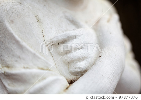 Hands on the chest. Old sculpture. 97877370