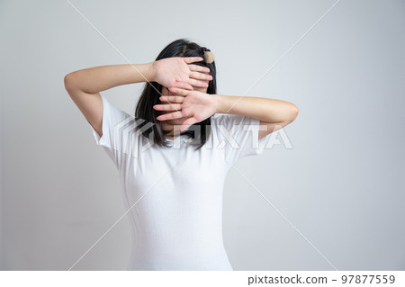 Young Asian glasses girl rises up her arms to cover her face in studio light white clear background. 97877559
