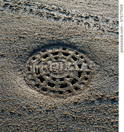 Manhole on the road in winter. 97877608
