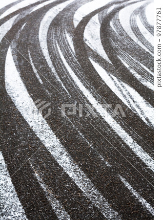 Wheel tracks on the road covered with snow Wheel tracks on the road covered with snow 97877761