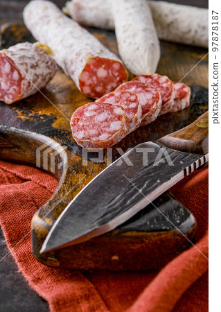 Fermented air-dried salami on wooden cutting board, closeup view Fermented air-dried salami on wooden cutting board, closeup view 97878187