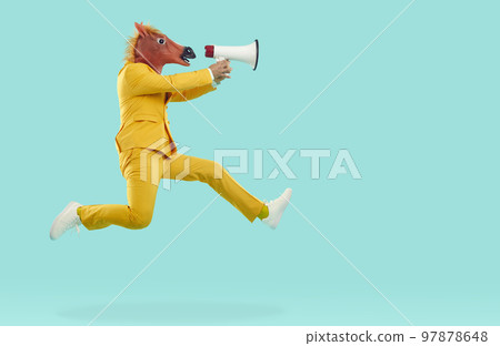 Man in horse head mask jumping and shouting in megaphone Man in horse head mask jumping and shouting in megaphone 97878648