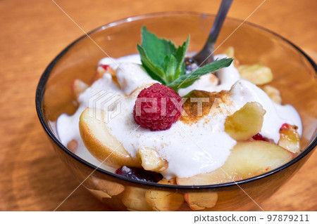 Fruit salad with yogurt in a transparent plate on the table close-up 97879211