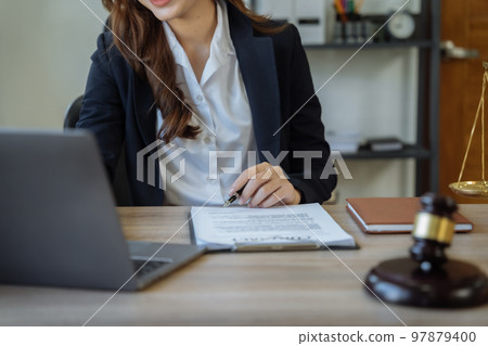 Lawyer signing important legal document on desk at office. Lawyer signing important legal document on desk at office. 97879400