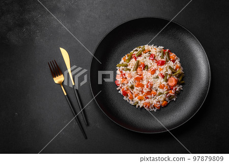 Delicious fresh risotto with vegetables, spices and herbs on a black plate 97879809