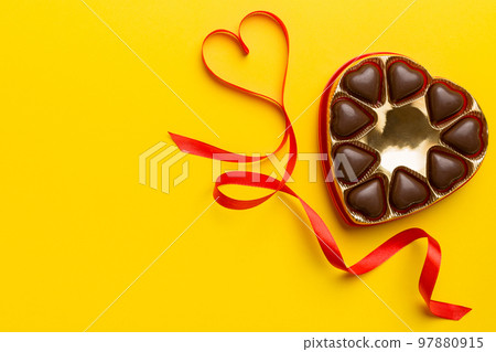 Delicious chocolate pralines in red box for Valentine's Day. Heart shaped box of chocolates top view with copy space 97880915