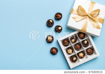 White box with chocolates candies and golden tape. top view with copy space White box with chocolates candies and golden tape. top view with copy space 97880918