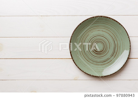 Top view of empty green plate on wooden background. Empty space for your design Top view of empty green plate on wooden background. Empty space for your design 97880943