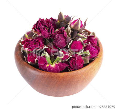 Heap of dry tea roses buds in wooden bowl, isolated on white background. Rose flower tea. Phnom Penh rose tea. Clipping path. 97881079