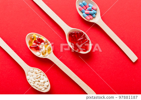 Vitamin capsules in a spoon on a colored background. Pills served as a healthy meal. Red soft gel vitamin supplement capsules on spoon Vitamin capsules in a spoon on a colored background. Pills served as a healthy meal. Red soft gel vitamin supplement capsules on spoon 97881187