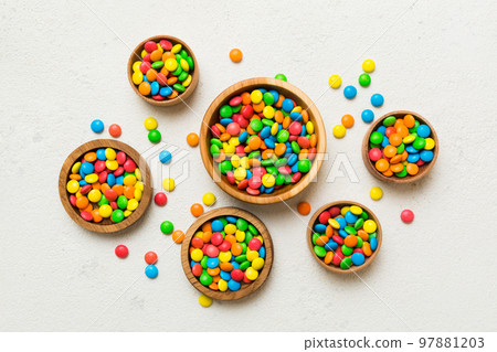 different colored round candy in bowl and jars. Top view of large variety sweets and candies with copy space different colored round candy in bowl and jars. Top view of large variety sweets and candies with copy space 97881203