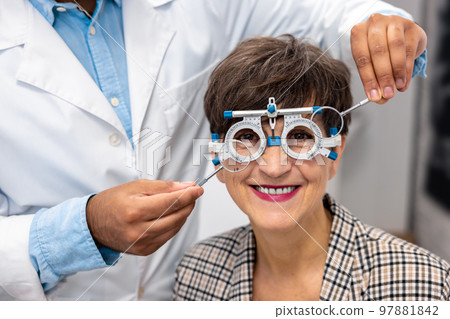 Optometrist working with female patient at clinic Optometrist working with female patient at clinic 97881842