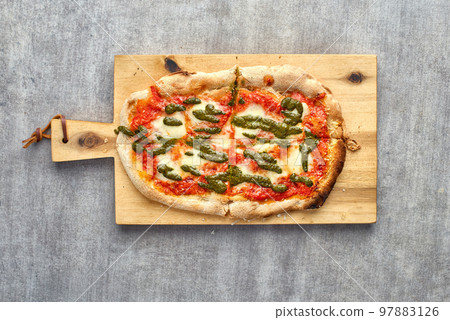 Fresh baked focaccia or pizza with mozzarella and pesto. 97883126