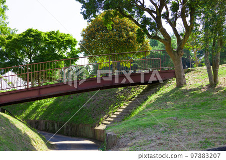 A golf course in the blue sky, a river-like cart road sandwiched between hills and an old rusty bridge passing over it (Kisarazu City, Chiba Prefecture) 97883207