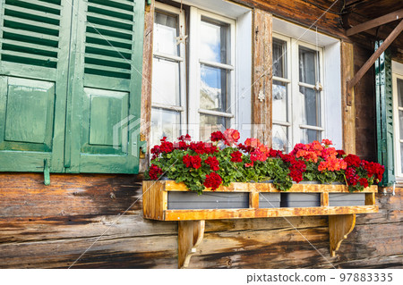 Flowers in rustic balcony at springtime with window, Interlaken, Switzerland 97883335