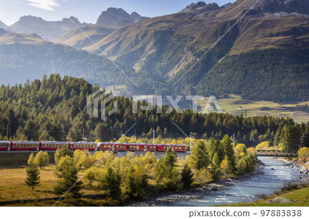 Swiss train in the alps and river around Bernina pass, Engadine, Switzerland 97883838