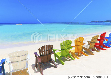 Colorful wooden chairs on white sand beach in Aruba, Duth Caribbean 97884081
