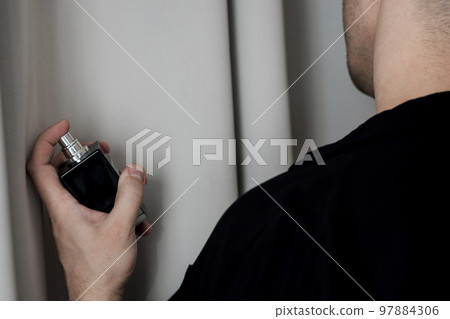 man holds a bottle of perfume man holds a bottle of perfume 97884306