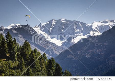 Paragliding above Bernina mountain range with glaciers in the Alps, Switzerland 97884430